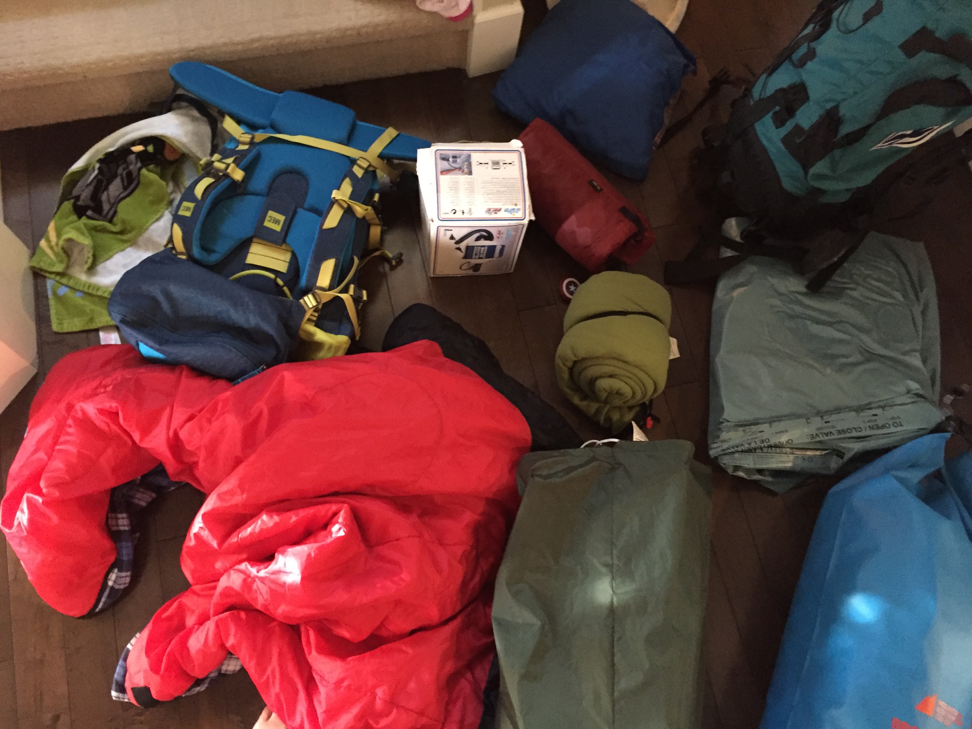 pile of camping gear by the door for how to pack for a road trip