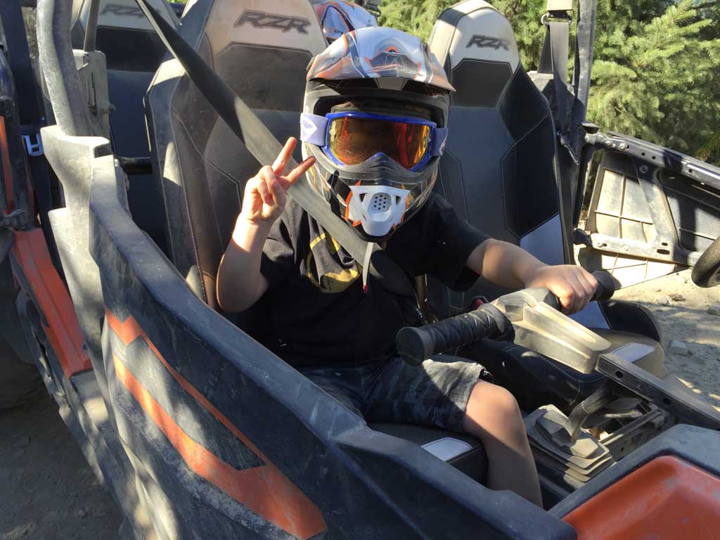 boy sitting in front seat of RZR during Whistler ATV Tours