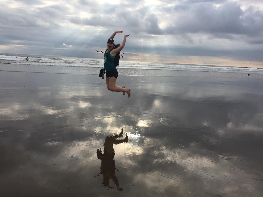 woman jumping on the beach in dominical, costa rica