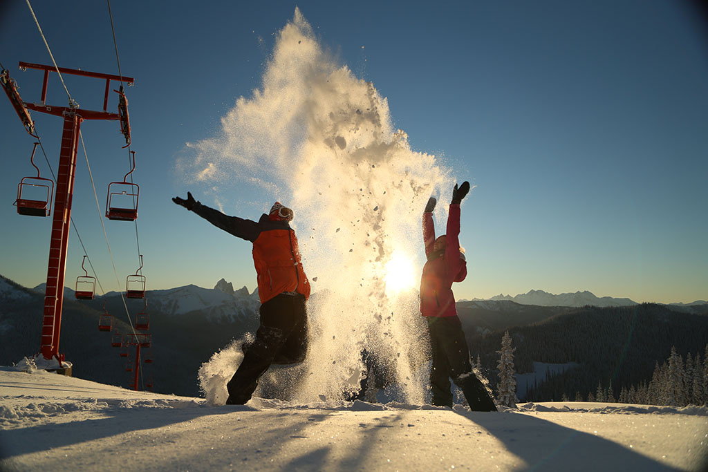 Two people throwing snow in Manning Park, one of the best family ski resorts in BC