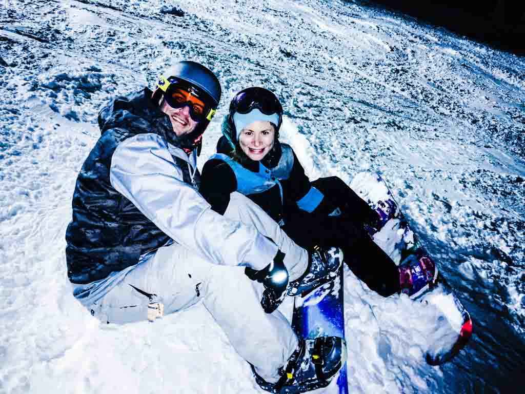 Jami Savage and husband snowboarding on their Big White family ski trip