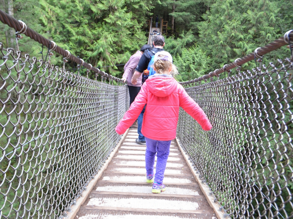 Girl walking over Lynn Canyon suspension bridge for Free Spring Break Activities in Vancouver 
