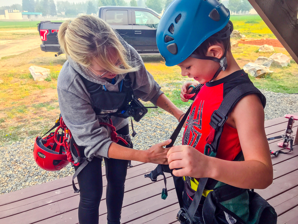 Boy getting on zipline gear at Treetop Flyers Zipline Kamloops