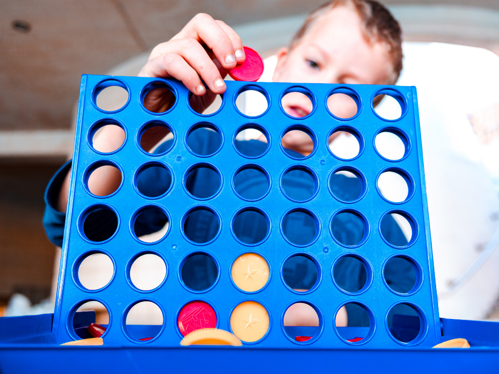 Boy playing connect four for backyard lawn games