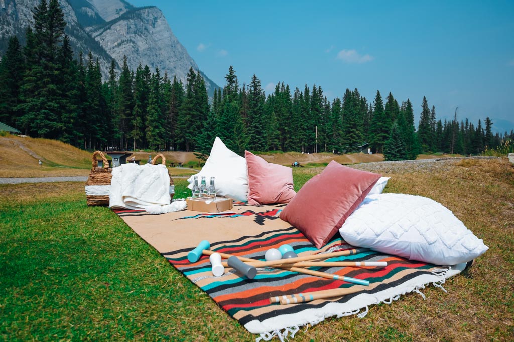 luxury picnic set up on the grass in front of a large mountain