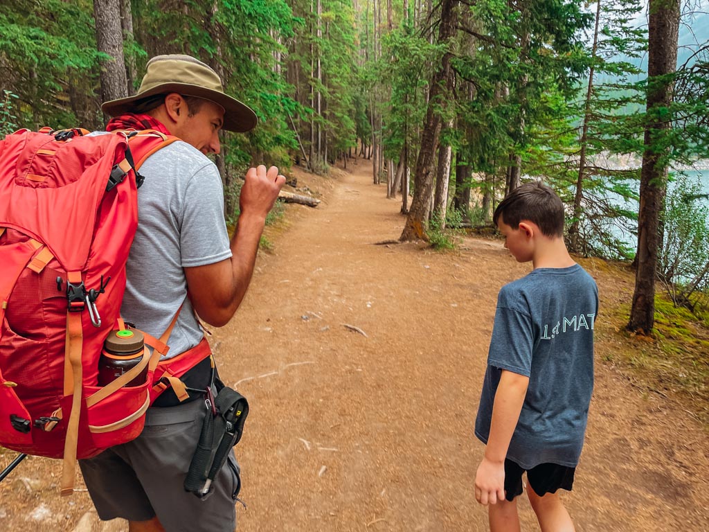 hiking guide explaining information to young boy on a trail
