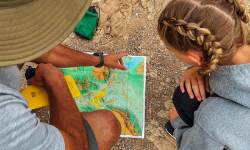 hiking guide showing a hiking map to a young girl