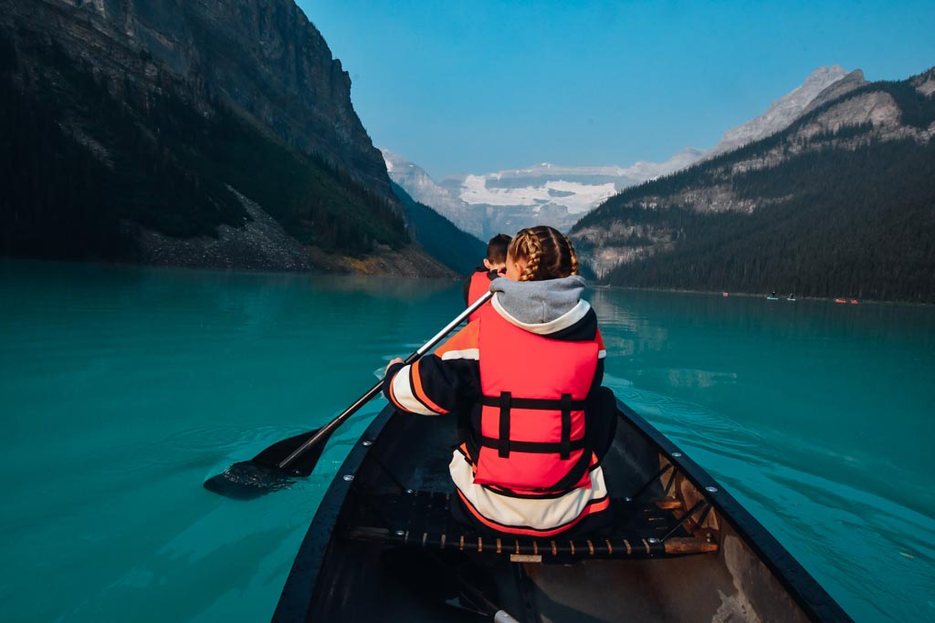 two kids paddling in a canoe on lake louise